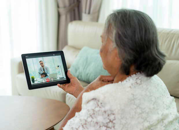 Woman on tablet video chatting with a doctor
